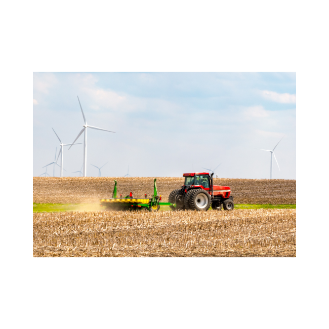 Picture of a red tractor plowing a field with blue sky and white clouds