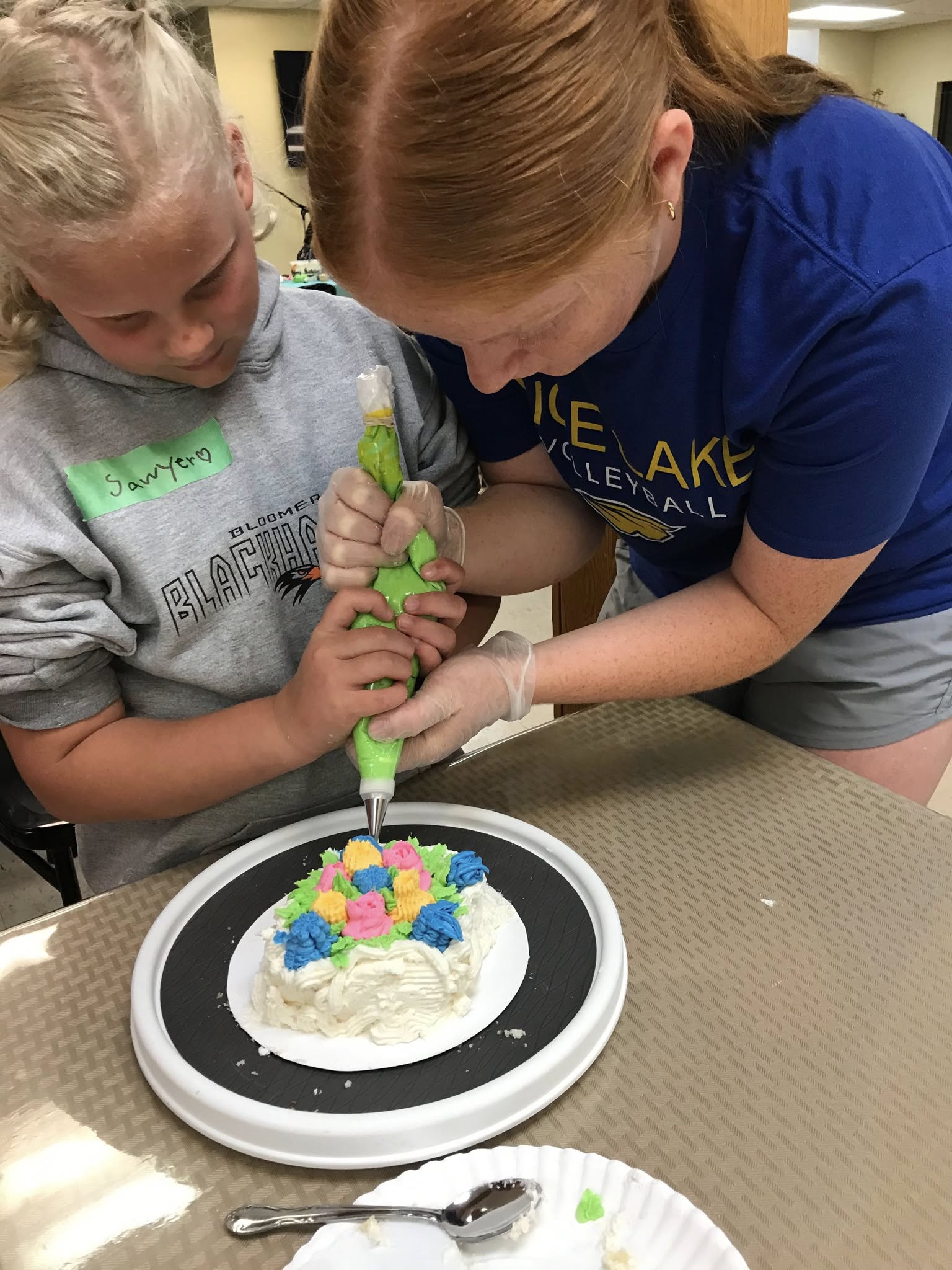 A picture of 2 girls decorating cake